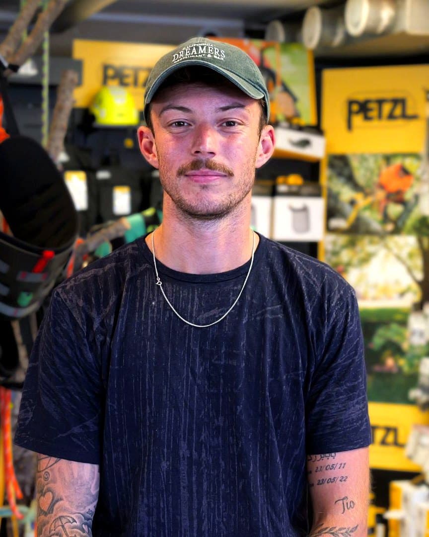 Michel Skogqvist i Arboristbutikens butik, framför klätterselar och Petzl-utrustning.